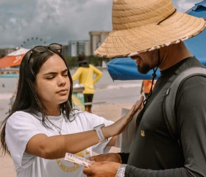 Campanha orienta trabalhadores da orla de Maceió sobre riscos do sol nos lábios e distribui protetor solar